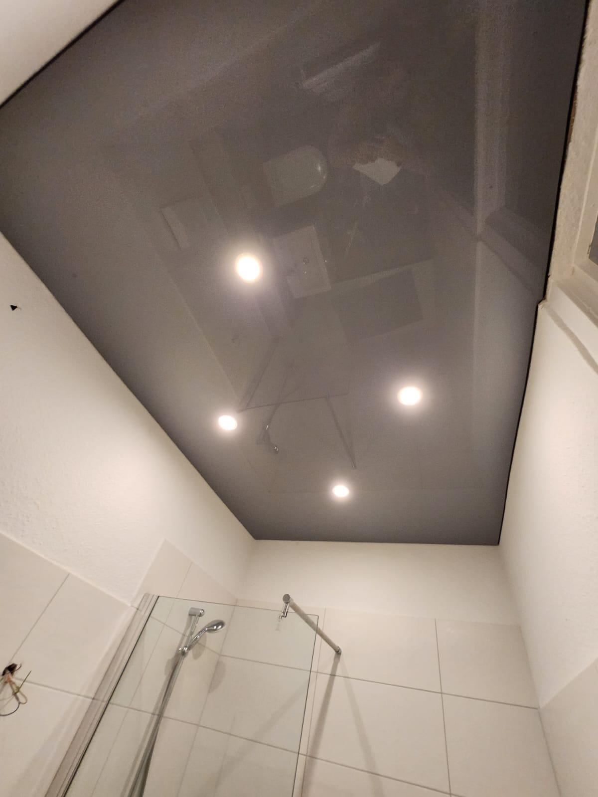 Hochglanz Lackspanndecke mit Spiegeleffekt und LED-Spots im modernen Wohnraum